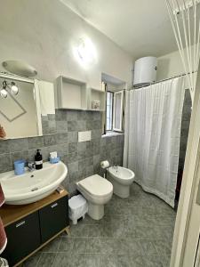 ein Badezimmer mit einem weißen WC und einem Waschbecken in der Unterkunft Monolocale Romeo in Locri