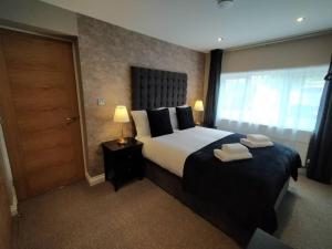 een slaapkamer met een groot bed en 2 handdoeken bij Twilight House - sleeps 7, driveway, gardens in Crewe