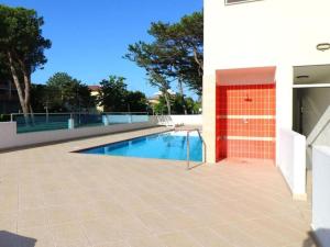 een zwembad naast een gebouw bij Enjoy poolside comfort - Beahost Rentals in Bibione
