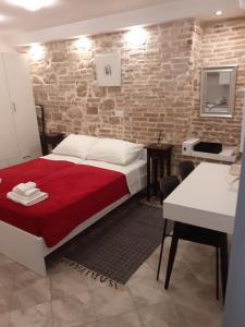 1 dormitorio con cama y pared de ladrillo en Studio Apartment Ana, en Zadar