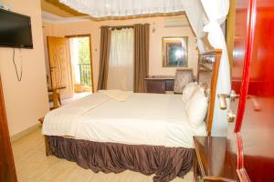 Habitación de hotel con cama y TV en Tana Garden Hotel, en Garissa
