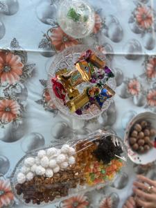 une table recouverte de assiettes de bonbons et de raisins dans l'établissement Şamaxı Cennetbagı Evi, à Şamaxı