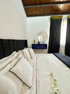 a bedroom with a bed with white sheets and a mirror at Enchantment in the Heart of Nature in Canicattini Bagni