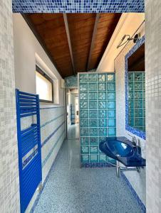 a bathroom with a blue sink and a tub at Enchantment in the Heart of Nature in Canicattini Bagni