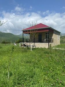 a building with a picnic table in a field at Şamaxı Cennetbagı Evi in Şamaxı