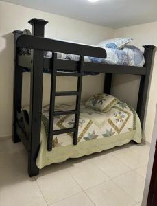 - un lit superposé noir avec un oreiller sur la couchette inférieure dans l'établissement Espectacular casa vacacional con garaje en Pereira, à Pereira