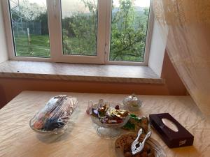 - une table avec de la nourriture et une fenêtre dans la chambre dans l'établissement Şamaxı Cennetbagı Evi, à Şamaxı