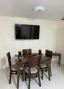 une salle à manger avec une table, des chaises et une télévision dans l'établissement Espectacular casa vacacional con garaje en Pereira, à Pereira