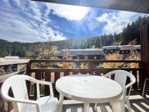 un tavolo bianco e sedie su un balcone con un treno di Résidence Parc Aux Etoiles - C210PAE - APPARTEMENT 2 CHAMBRES AVEC BALCON MAE-8234 a Narreyroux