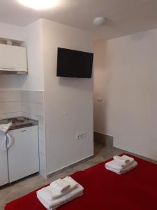 a kitchen with a red bed with towels on it at Studio Apartment Ana in Zadar