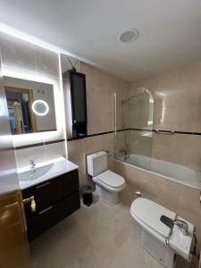 a bathroom with a toilet and a sink and a shower at LUARCAPLAYA APARTAMENTO Plazas de garaje incluidas in Luarca