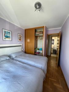 a bedroom with two beds and a ceiling fan at LUARCAPLAYA APARTAMENTO Plazas de garaje incluidas in Luarca