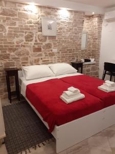 a bedroom with a large bed with a red blanket at Studio Apartment Ana in Zadar