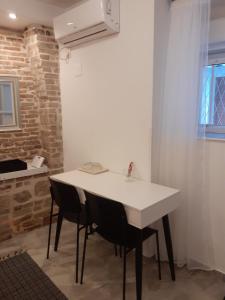 a kitchen with a white table and two chairs at Studio Apartment Ana in Zadar
