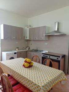 a kitchen with a table with a plate of fruit on it at Casa Scottodiuccio in Procida