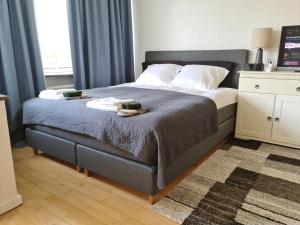 a bedroom with a bed with two towels on it at Bayer Apartments Copenhagen in Rødovre