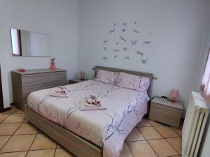 1 dormitorio con 1 cama con sábanas rosas y corazones en la pared en La Corte di Cris, en Lacchiarella