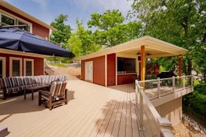 a wooden deck with a large umbrella and chairs at Barba Le Lane in Lake Ozark