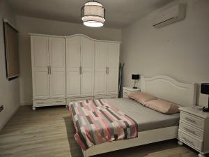 a bedroom with a bed and a white cabinet at Sea View over Valletta Harbour 3 bedrooms 2 S4 in Sliema