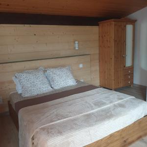 una camera con un grande letto e una parete in legno di Appartement Grésival a Chapareillan