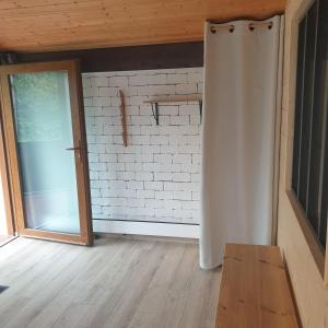 a room with a white brick wall and a sliding door at Appartement Grésival in Chapareillan