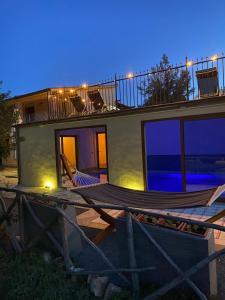 ein Haus mit einer Terrasse, einem Tisch und Stühlen in der Unterkunft Wild sud Sardinia 2 in Teulada