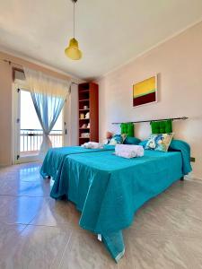 - une chambre avec un grand lit et une couverture bleue dans l'établissement Onda Blu Apartment, à Pizzo