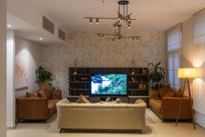 - un salon avec un canapé et une télévision dans l'établissement AlZaha Villa Muscat Bay, à Mascate