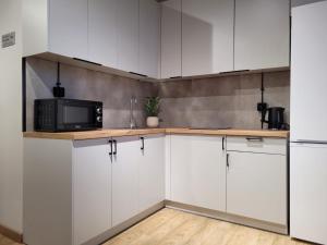 a kitchen with white cabinets and a microwave at Axo-Hostel 4 in Stalowa Wola