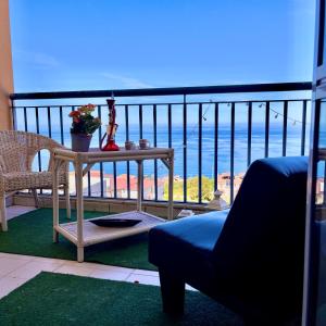 een balkon met een tafel en een stoel en de oceaan bij Onda Blu Apartment in Pizzo