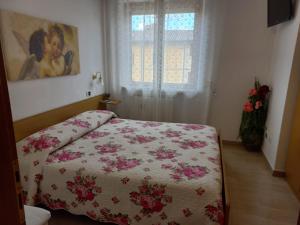 1 dormitorio con 1 cama con manta de flores en Casa Stefy Gubbio Centro, en Gubbio
