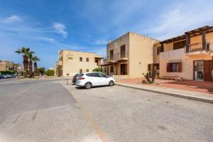 una macchina bianca parcheggiata sul lato di una strada di Virgilio House a San Vito lo Capo