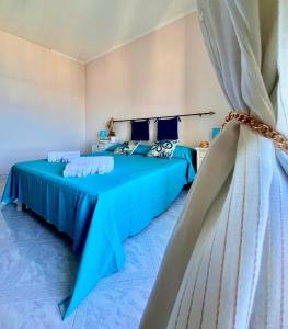 een slaapkamer met 2 bedden met blauwe lakens bij Onda Blu Apartment in Pizzo