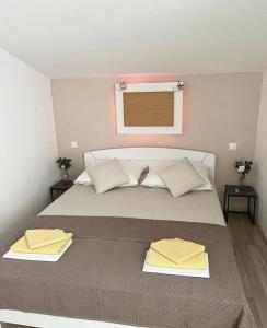 - une chambre avec un grand lit et 2 oreillers jaunes dans l'établissement Apartments Vero 2-4 Personen, à Orebić