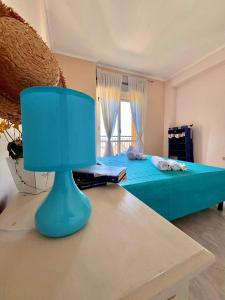 een slaapkamer met een blauw bed en een raam bij Onda Blu Apartment in Pizzo