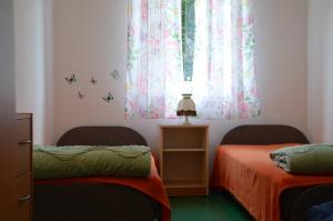 Pokój z 2 łóżkami i oknem z motylami w obiekcie Stara Pastorówka w mieście Dąbki