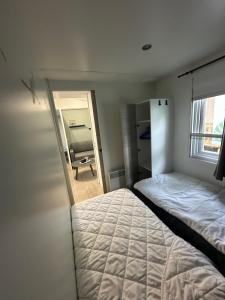 un dormitorio con una cama y un espejo en camping 4 Etoiles A ST JEANS-DE-MONTS Mobil home 4à6 pers, en Saint-Jean-de-Monts
