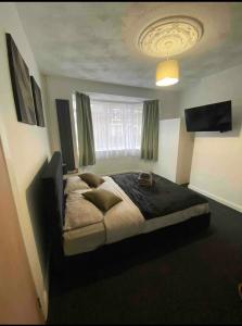a bedroom with a large bed in front of a window at Luxury king en-suite room in Peterborough