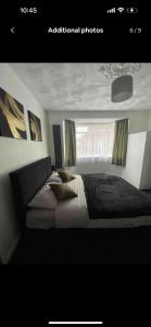 a bedroom with a large bed with a window at Luxury king en-suite room in Peterborough