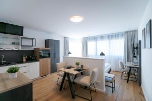 a kitchen and living room with a table and chairs at Helios Berlin Apartments in Berlin