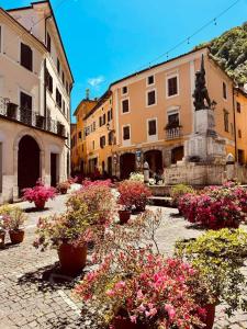 Supino的住宿－Casina di Paolo e Maria，庭院里种满了鲜花,还有雕像和建筑