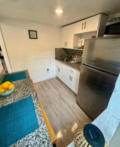 a kitchen with a stainless steel refrigerator and wooden floors at Nice Queen Bedroom - Best Location in Miami - Luggage Storage Service, Parking and Laundry for free!!!! in Miami