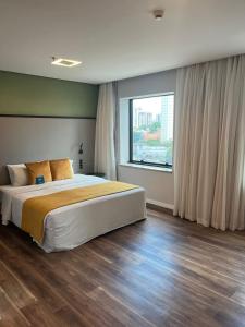 um quarto com uma cama grande e uma janela grande em Blue Tree Premium Morumbi em São Paulo