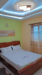 - une chambre avec un grand lit et un plafond avec une fenêtre dans l'établissement BOSSLIFE APARTMENTS-TERMINUS SAINT MICHEL DERRIERE Barcelone Hôtel, à Douala
