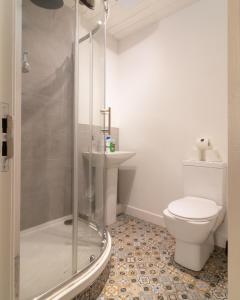 a bathroom with a shower and a toilet and a sink at Belfast Quarters: Modern City Centre Hub 3 Bed in Belfast