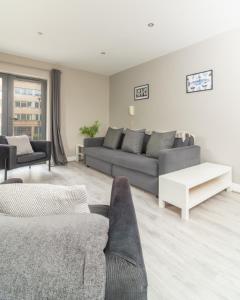 a living room with a couch and a table at Belfast Quarters: Modern City Centre Hub 3 Bed in Belfast