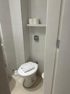 uma casa de banho branca com WC e algumas toalhas em Maravilha no Rio de Janeiro