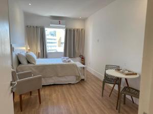 a bedroom with a bed and a table and chairs at Maravilha in Rio de Janeiro