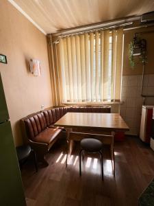 una sala da pranzo con tavolo, sedie e finestra di 2-х ком. квартира, р-н фонтан "ROSHEN" a Vinnycja
