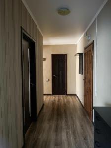 un couloir vide avec deux portes et du parquet dans l'établissement 2-х ком. квартира, р-н фонтан "ROSHEN", à Vinnytsia